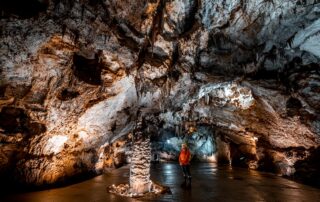 Speleologist standing in the grand Njegos Hall of Lipa Cave, Cetinje Montenegro