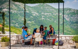 Family relaxing on the terrace of Caffe Bar Lipa with mountain views, Cetinje Montenegro