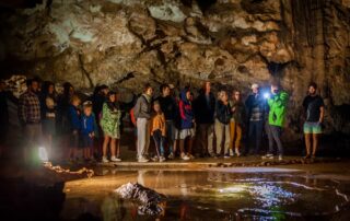 Tour group beside natural dripping water formation inside Lipa Cave, Montenegro
