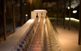 Wine glasses and bottles set up for a tasting event inside Lipa Cave, Montenegro