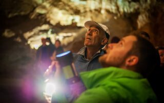 Visitors looking up at cave ceiling inside Lipa Cave, Cetinje Montenegro